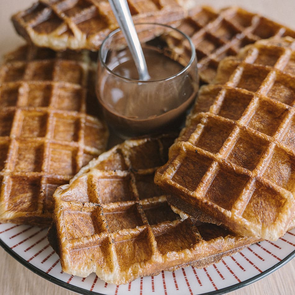 Croffle dans une assiette avec une sauce au chocolat maison